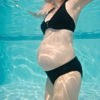 Pregnant woman's torso under water